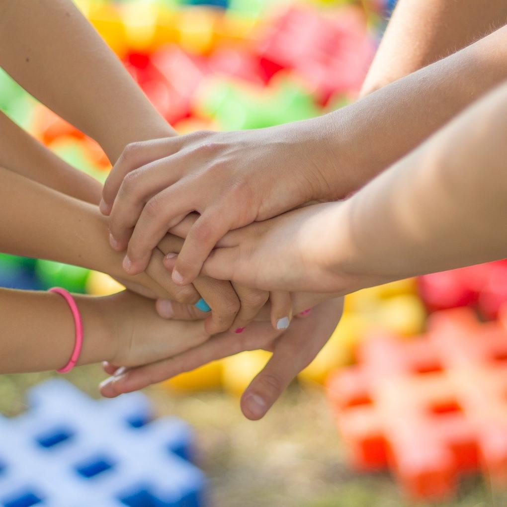 Sich überkreuzende und reichende Kinderhände